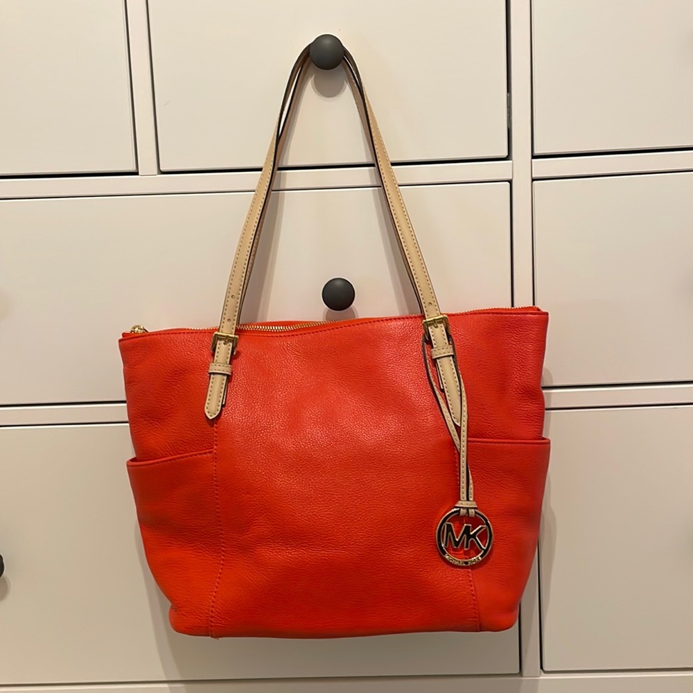 Michael Kors handbag. Carried very little. It is a red orange color. Like new